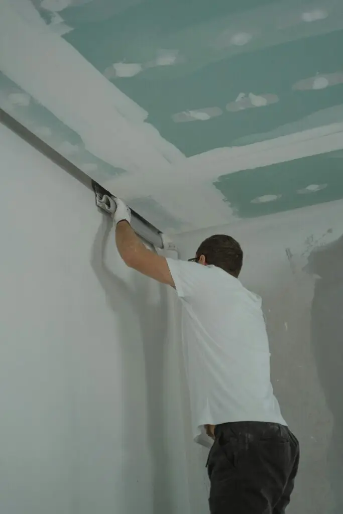 A man painting a ceiling